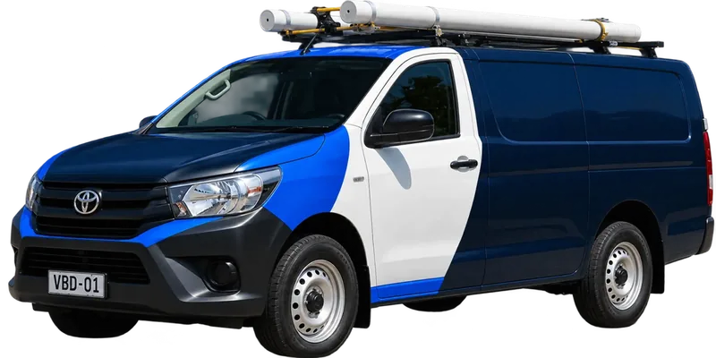 A licensed Wahroonga plumbing van loaded with pipe on the roof rack